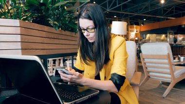 Genç bir uzman, bir kafede uzaktan çalışıyor..