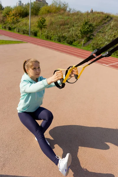 Training op straat, een jonge vrouwelijke atleet maakt een training op het stratenplatform. — Stockfoto