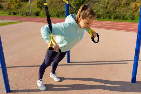 Outdoor fitness, openbaar sportveld. Een jonge sportvrouw doet een training op straat, — Stockfoto