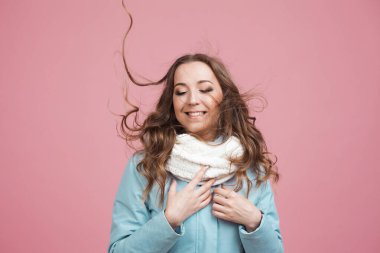 Mavi kışlık ceketli, atkılı, saçları rüzgarda uçuşan hoş bir kadın..