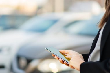 Mobil taksi servisi, şehirdeki modern teknolojiler. Bir kadın telefonunu araba aramak için kullanır..