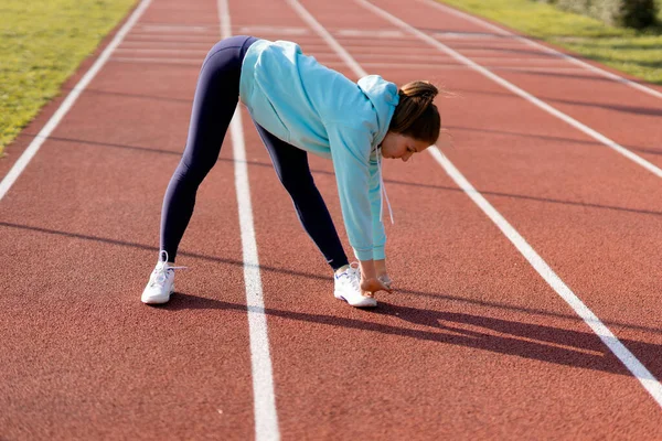 Training on the street, a young female athlete makes a workout on the street platform.