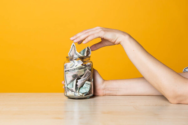 Money in the Bank, deposits and accounts concept. Dollar bills in a glass jar