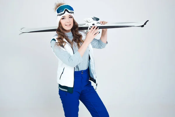 Skieuse souriante dans un chapeau et un masque pour skier. Une jeune femme vêtue pour le ski et les activités de plein air. — Photo