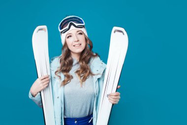 Eğlence kayakçısı kayak yapmaya hazırlanıyor. Ekipmanlı ve kayaklı genç bir kadın.,