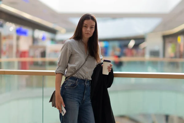Jonge vrouw in jeans en casual kleding in een winkelcentrum. — Stockfoto
