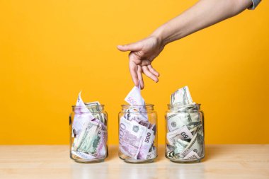 Çoklu para hesapları, konsept. Parlak sarı bir arka planda cam bir kavanozda dolar ve avro..