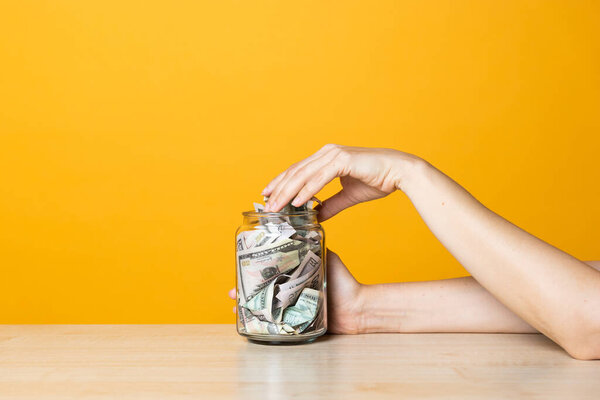 Money in the Bank, deposits and accounts concept. Dollar bills in a glass jar