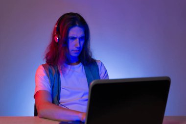 Bir dizüstü bilgisayarda öğrenci ya da programcı, neon boyama portresi. Komik çocuk. Kod yazıyor..