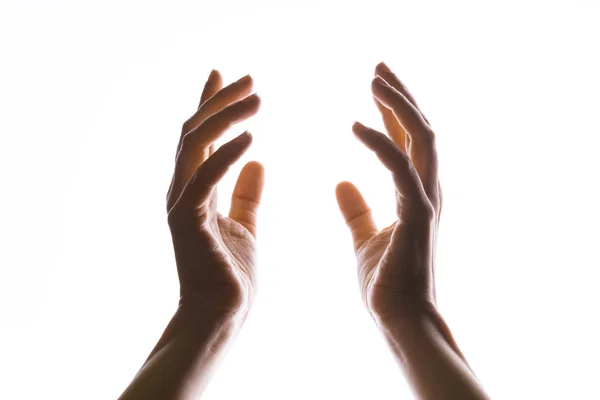 As mãos fazem magia, ou rezam para que a luz caia de cima na mão. Radiância entre as palmas das mãos. — Fotografia de Stock