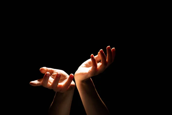 Beautiful folded hands with light on top, black background. Prayer or creating a miracle. — Stock Photo, Image