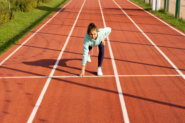 Training on the street, a young female athlete makes a workout on the street platform.