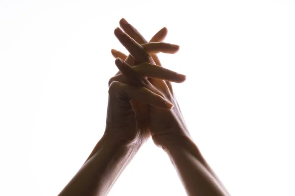 Praying crossed hands on a white background. Light from above. Hands folded in prayer. — Stock Photo, Image