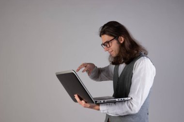 Eğitim ve yeni teknolojiler, çevrimiçi kurslar, e-öğrenme. Uzun saçlı ve gözlüklü genç bir adam..