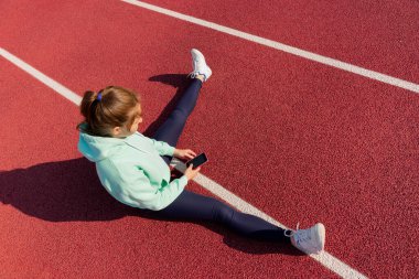 Sokakta antrenman yapan genç bir bayan sporcu sokak platformunda antrenman yapıyor..