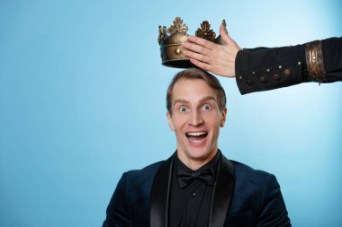 Hedefe, konsepte başarıyla ulaşan yeni lider. Takım elbiseli genç bir işadamının başında bir taç..