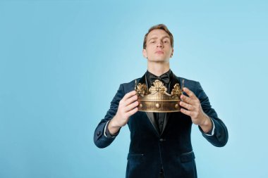 Kral ol, taç tak ya da en iyisini ödüllendir. Elinde tacı olan bir adam.,