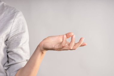 Yan tarafı gösteren zarif bir kadın eli. Avuç içi bir şey tutuyor, tasarım için bir boşluk..