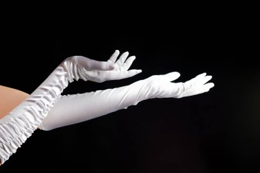 El hareketleriyle. Uzun beyaz eldivenli bayan yan tarafı işaret ediyor, bir sihir gösterisi..