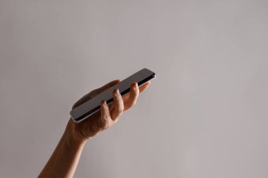 Bir kadının elindeki ince modern akıllı telefon, telefonundaki internet ya da uygulamaları kullan.