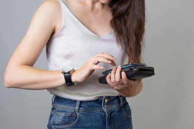 Para saymak, kişisel bütçeyi korumak, konsept. Elinde çantası olan genç bir kadın.,