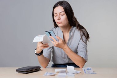 Harcamalar geliri aşıyor, üzgün genç kadın aile bütçesini yönetiyor.,