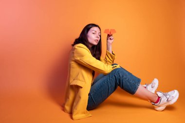 Kağıt uçak fırlatmak, bir başlangıç konsepti. Genç esmer kadın.