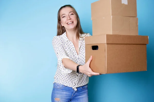 Accept a parcel, happy young woman holding a stack of cardboard boxes,