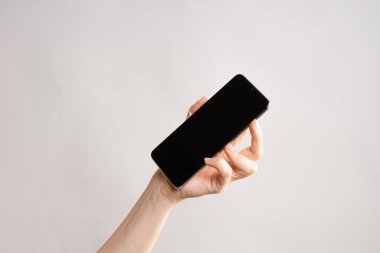 Bir kadının elindeki ince modern akıllı telefon, telefonundaki internet ya da uygulamaları kullan.