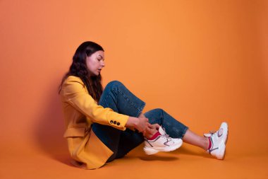 Genç bayan beyaz spor ayakkabılarını giyer. Rahat ve şık ayakkabılar.,