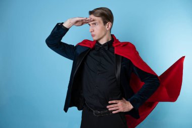 Süper kahraman acele eder. Kırmızı pelerinli genç bir adam, süper adam..