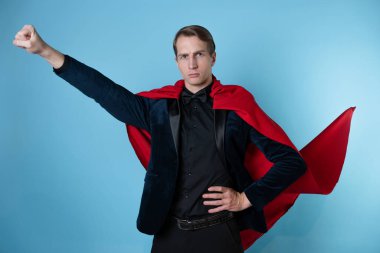 Süper kahraman acele eder. Kırmızı pelerinli genç bir adam, süper adam..