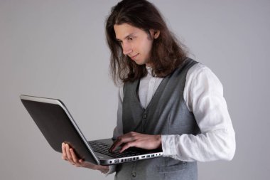 Eğitim ve yeni teknolojiler, çevrimiçi kurslar, e-öğrenme. Uzun saçlı genç bir adam.