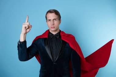 Süper kahraman acele eder. Kırmızı pelerinli genç bir adam, süper adam..