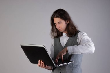 Eğitim ve yeni teknolojiler, çevrimiçi kurslar, e-öğrenme. Uzun saçlı genç bir adam.