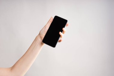 Bir kadının elinde dokunmatik ekranlı akıllı telefon. Tasarımınız için bir dokunmatik ped ile telefonunuzu kullanın..