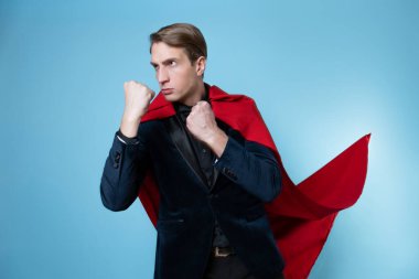 Süper kahraman koruyor. Kırmızı pelerinli genç bir adam, süper adam..
