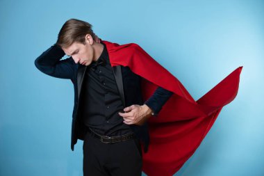 Süper kahraman kılığında kırmızı pelerinli bir iş adamı sorunu düşündü.,