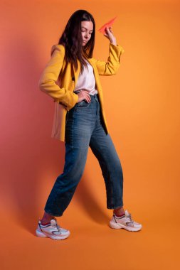 Kağıt uçak fırlatmak, online para transferi konsepti. Genç esmer kadın.