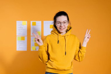 Mutlu öğrenci araştırmasını öğretmenin ve diğer öğrencilerin önünde sunar.,