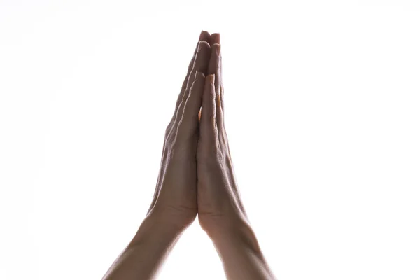Des mains priantes sur un fond blanc. Lumière d'en haut. Les mains jointes dans la prière. Les gestes de la main — Photo