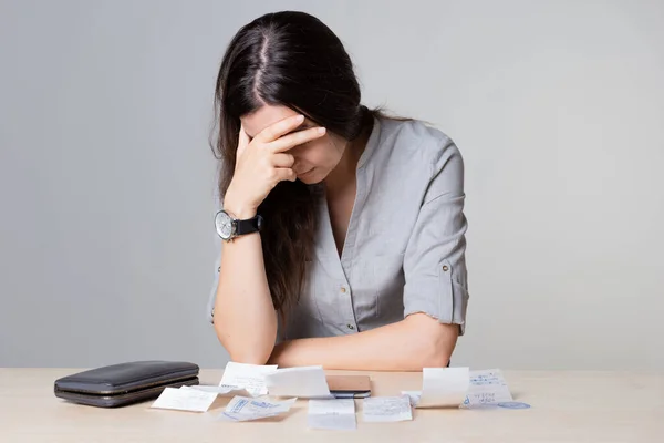 Spending exceeds income, a sad young woman sits clutching her head — Stock Photo, Image