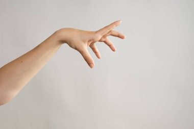 El hareketleriyle. Zombi elleri saldırıyor, çarpık parmaklarıyla bir şeyi tutuyor..