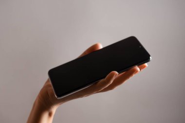 Bir kadının elindeki ince modern akıllı telefon, telefonundaki internet ya da uygulamaları kullan.