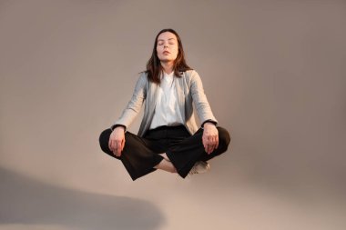 İş yerinde meditasyon ve stres kontrolü, takım elbiseli genç bir kadın.,