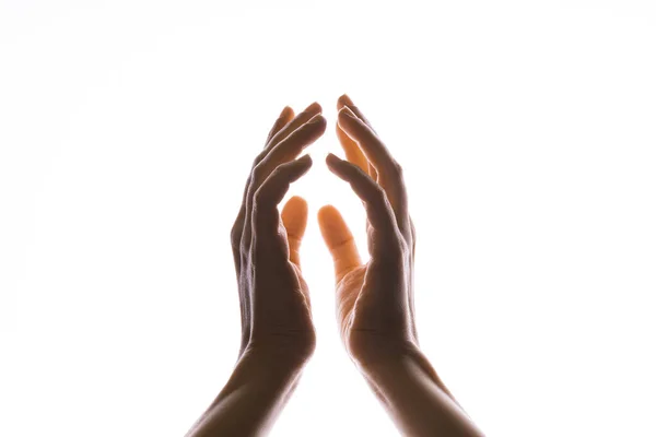 Hände zaubern oder beten, dass das Licht von oben auf die Hand fällt. Strahlkraft zwischen den Handflächen. — Stockfoto