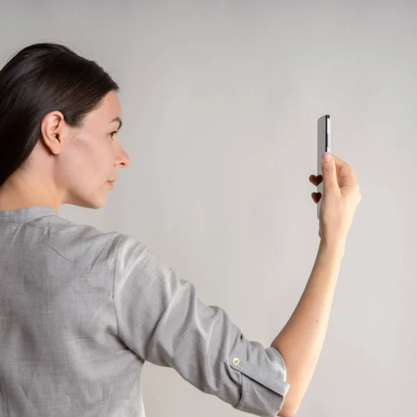 Γυναίκα κρατά το smartphone μπροστά από τα μάτια της και ξεκλειδώνει το τηλέφωνο μέσω id πρόσωπο. — Φωτογραφία Αρχείου