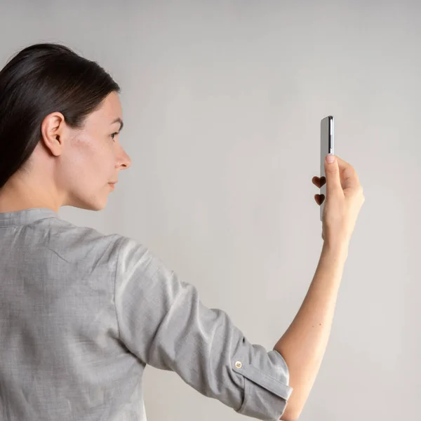 Woman holds the smartphone in front of her eyes and unlocks the phone via face id. — Stock Photo, Image