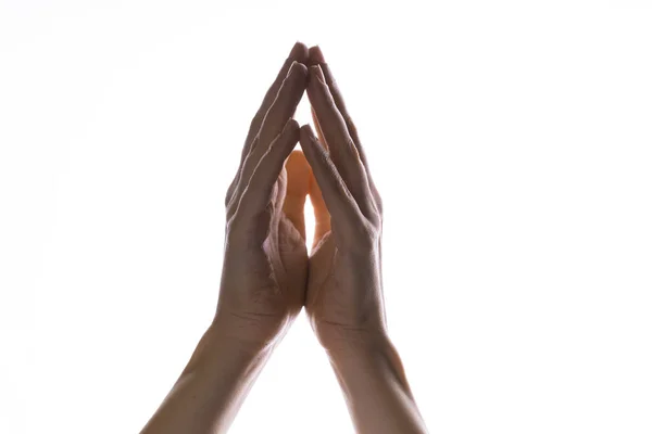 Orando con las manos sobre un fondo blanco. Luz desde arriba. Las manos dobladas en oración. Gestos de mano — Foto de Stock