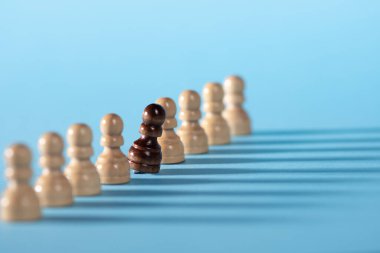 Arka arkaya satranç taşları, mavi arka planda beyaz piyonlar.,